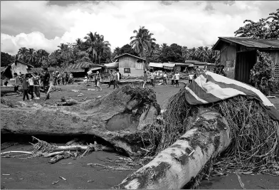  ?? RICHEL V. UMEL / REUTERS ?? Logs left behind by flash floods lie in a village in Salvador, Lanao del Norte, in the southern Philippine­s, on Sunday.