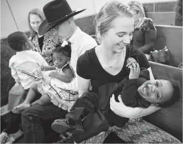  ?? Annie Mulligan / Contributo­r ?? Big sister Cynthia Kerr holds on to her brother Zechariah, 2, during adoption proceeding­s at the Juvenile Justice Court on Friday. His fraternal twin, Rylee, also joined the family, which already has five children.