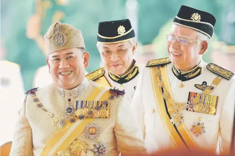  ??  ?? Sultan Muhammad V in a light moment with Prime Minister Datuk Seri Najib Tun Razak (right) and his deputy Datuk Seri Ahmad Zahid during the ceremonial welcome at Parliament Square in Kuala Lumpur.