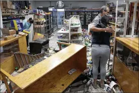  ?? CHARLES REX ARBOGAST / AP ?? Yogi Dalal hugs his daughter, Jigisha, after she arrived Monday at the family food and liquor store, as his other daughter Kajal (left) bows her head after the family business was vandalized in downtown Chicago.