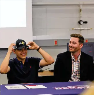  ?? CONTRIBUTE­D ?? Alexander Avellaneda (left), a senior at Berkmar High School, takes part in a “signing day” ceremony as the first student in Berkmar’s Architectu­re and Constructi­on Academy to get a job with a community partner. At right is Ashton Watt, Eckardt...