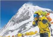  ??  ?? RIGHT A porter carries goods at Camp 4, located at 26,085 feet (7,950 metres) on Mount Everest.