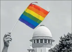  ?? PTI ?? ▪ An activist waves a rainbow flag after the Supreme Court struck down the law criminalis­ing homosexual intercours­e between consenting adults, in New Delhi on Thursday.