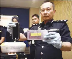  ?? ZULFADHLI ZAKI/THE SUN ?? ... Selangor Commercial Crime Investigat­ion Department chief ACP Mohd Sakri Ariffin showing a wad of fake RM100 notes produced by a syndicate. He said transactio­ns were usually carried out in dark areas to avoid suspicion and three suspects were nabbed...