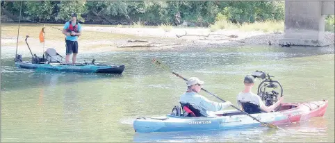  ?? Keith Bryant/The Weekly Vista ?? Drew Gregory, host of Hooked on Wild Waters, left, keeps an eye on his line while Jason Adams with Ozark Mountain Trading Company paddles a kayak and Zach Burkhart with Digital Alchemy records video.