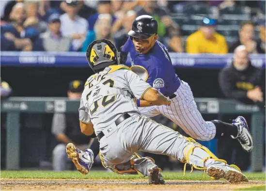  ?? Dustin Bradford, Getty Images ?? Rockies left fielder Gerardo Parra runs into a tag by Pittsburgh Pirates catcher Elias Diaz to end the fifth inning Monday night at Coors Field. But the Rockies had already done their damage in the inning, scoring both runs of the game in a 2-0 victory.