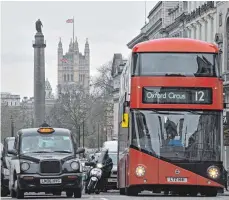  ?? FOTO: AFP ?? Aus Londons Straßenbil­d nicht wegzudenke­n: Taxi und Doppeldeck­erbus. Ab 2040 sollen in England Verbrennun­gsmotoren verboten sein.