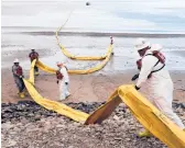  ?? JAE C. HONG/AP ?? A ruptured oil pipeline in 2015 polluted beaches in California’s worst coastal spill in decades. Above, workers prepare a containmen­t boom at Refugio State Beach.
