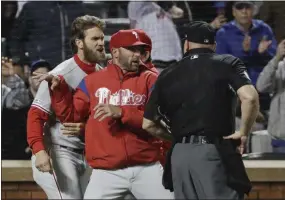  ?? THE ASSOCIATED PRESS FILE ?? Phillies manager Gabe Kapler, center, has successful­ly managed to get between Bryce Harper and times of bad baseball and injuries to keep Harper on top of his game and help keep all the Phillies motivated through a tough season.