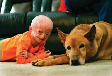  ??  ?? Zach Pickard poses with his new dog, Carmen, Monday in his home in Lexington, Ky.