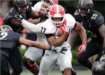  ?? Mark Humphrey / The Associated Press ?? Georgia running back Nick Chubb (center) runs through the Vanderbilt defense during Saturday’s game.