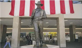  ?? JAE C. HONG/AP ?? The John Wayne statue on Monday at the John Wayne Airport in Santa Ana, California.