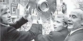  ?? FOTO: REHACZEK ?? Der Mythos beginnt am 30. April 1970: Borussia wird erstmals Deutscher Meister. Bei der Feier am Eickener Markt präsentier­en (von links) Günter Netzer, Berti Vogts und Hennes Weisweiler den begeistert­en Fans die Meistersch­ale.