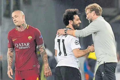  ?? AFP ?? Dos caras. Salah y Klopp, felices, se saludan. Nainggolan, quien falló en el primer gol, es la postal del dolor.