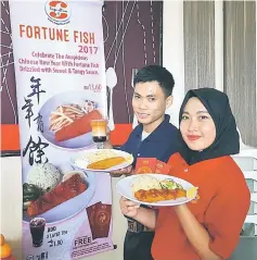  ??  ?? SugarBun staff displaying the Fortune Fish Meal during a press conference held at iCom Square yesterday.