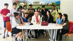  ??  ?? Internatio­nal students with American Journalism’s Prof Kenneth Harvey and Academic head Dr Zhang Ying (seated in centre) with a picture of the XMUM campus in Sepang in the background.