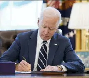  ?? ANDREW HARNIK - THE ASSOCIATED PRESS ?? President Joe Biden signs the American Rescue Plan, a coronaviru­s relief package, in the Oval Office of the White House, Thursday, March 11, 2021, in Washington.