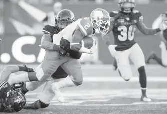  ?? THE CANADIAN PRESS ?? B.C. Lions running back Chris Rainey is tackled by Tiger-Cats linebacker­s Nick Shortill (23) and Lucas Wacha (43) during second-half CFL action in Hamilton, Ont. on Saturday.