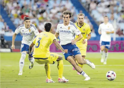  ?? ÁNGEL DE CASTRO ?? Goleador en el estreno Francho Serrano trata de marcharse de Tasende en el partido ante el Villarreal B en La Romareda. -