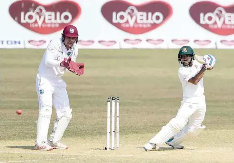  ?? — AFP ?? Bangladesh’s Mehidy Hasan Miraz (R) plays a shot during the second day of the first Test against the West Indies in Chittagong.