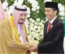  ?? — Reuters ?? Saudi King Salman shakes hands with Indonesian President Joko Widodo during their meeting at the presidenti­al palace in Bogor on Wednesday.