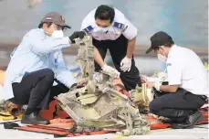  ?? ALANGKARA/AP DITA ?? Indonesia plane crash: Investigat­ors inspect pieces of downed Sriwijaya Air flight SJ-182 Thursday in Jakarta, Indonesia. Authoritie­s ended the search for the wreckage of the plane that nosedived Jan. 9 into the Java Sea, killing all 62 people on board. A limited search for the missing memory unit from the cockpit voice recorder will continue.