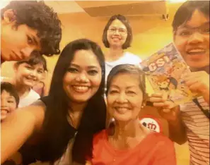  ??  ?? Full of grace: In her younger days, ng loved wearing the kebaya for outings. (Right) ng with her daughters Pearlisha (third from right) and Reisha (background) and her grandchild­ren.