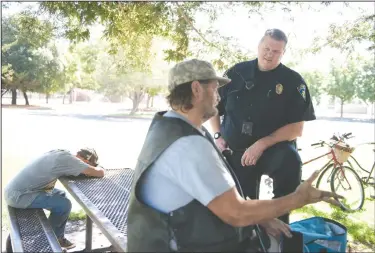  ?? NEWS-SENTINEL PHOTOGRAPH­S BY BEA AHBECK ?? Lodi Police Community Liaison Officer Ryan Holz talks with Kristofer Green in Lodi on Friday morning.