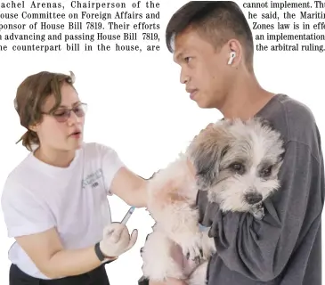  ?? PHOTOGRAPH BY KING RODRIGUEZ FOR THE DAILY TRIBUNE ?? DOG owners make the most of their day by allowing their pets to see city vets for vaccine shots, as the city government of Manila set up a stall along San Andres, Manila, yesterday to provide free rabies and deworming vaccines.