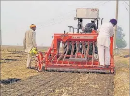  ?? SANJEEV KUMAR/HT ?? A farmer using a tractor-mounted super seeder, a machine with a combinatio­n of rotary tiller and seed planter with press wheels used for sowing wheat in paddy residue without burning straw, at a village in Bathinda .