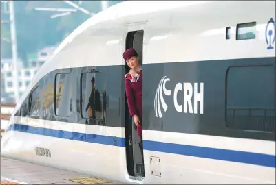  ?? ZOU HONG / CHINA DAILY ?? An attendant looks out a train station in Guanling, Guizhou province. Guanlin is one of the stations on the Shanghai-Kunming high-speed railway.