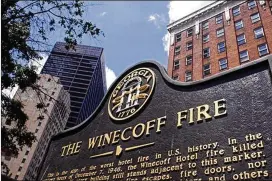  ?? COURTESY OF JOHN AMIS ?? A marker stands in front of the old Winecoff hotel in downtown Atlanta. It reads, in part, “The Winecoff fire became the watershed event in fire safety. Within days, cities across America began enacting more stringent safety ordinances.”