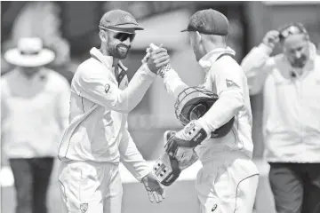  ?? - AFP photo ?? Australia’s Peter Nevill (centre R) with teammate Nathan Lyon celebrate their win on day four of the first cricket Test match between New Zealand and Australia at the Basin Reserve in Wellington.