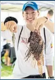  ?? GABBY MAGALSKI/COURTESY ?? Ashley Yarbrough, an intern with REEF Education Leadership, poses with a small and large lionfish captured during the derby.