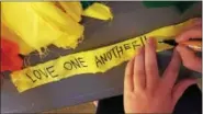  ??  ?? One of many messages of peace and love were written on strips of cloth during a vigil service in Phoenixvil­le Monday night at St. Vincent United Church of Christ. The strips of cloth will be tied together to form a prayer flag for the LGBT community in...