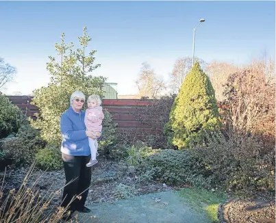  ?? Picture: Paul Reid. ?? Objector Lorna Wotherspoo­n, who made an impassione­d plea for the mast to be rejected, in her garden with granddaugh­ter Chloe, 2, near the planned site on Cortachy Road.