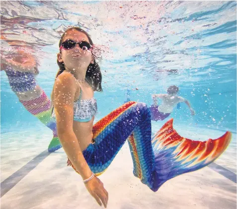  ??  ?? Mermaiding students swim in their tails during a Mayim Mermaid Academy lesson at the swimming pool at Bournemout­h Collegiate School