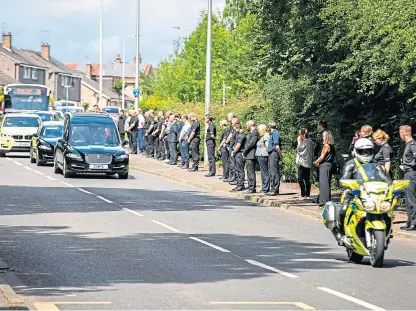  ??  ?? Police line the road in Dunfermlin­e during the funeral procession of Inspector Chris Mutter.