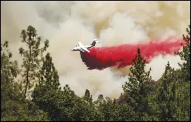  ?? ASSOCIATED PRESS ?? An air tanker drops retardant, Sunday, while trying to stop the Oak Fire from progressin­g in Mariposa County.