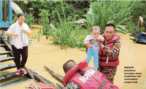  ??  ?? ANGGOTA penyelamat bertungkus-lumus menjalanka­n misi memindahka­n mangsa banjir.