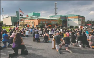  ?? (St. Louis Post-Dispatch/Christian Gooden) ?? Hundreds kneel in the St. Ann police station parking lot on June 9 for an 8-minute, 46-second moment of silence during a pause of a Black Lives Matter march down St. Charles Rock Road in St. Ann, Mo. The event was organized mostly by St. Ann residents.