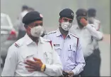  ??  ?? ▪ Traffic police officers wearing a face mask in Delhi.