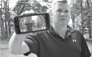  ?? JESSICA HILL/ASSOCIATED PRESS ?? Ernie Field holds up a live video of himself taken by a Ring doorbell camera at the front door of his home Tuesday in Wolcott, Conn.