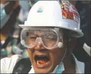  ??  ?? A protester wears a safety helmet and eye protector as he shouts slogans during a protest against a military coup in Yangon.