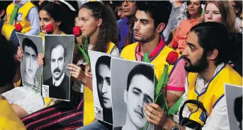  ?? ZAKARIA ABDELKAFI/AFP/GETTY IMAGES ?? People hold up pictures of relatives killed by the Iranian regime during a protest last month in Villepinte, north of Paris. Tens of thousands attended the event from across the world.