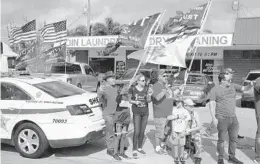  ?? PATRICK SEMANSKY/AP ?? Supporters of President Donald Trump watch as his motorcade passes by in West Palm Beach on Dec. 31.