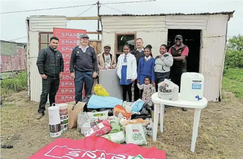  ?? Picture: SUPPLIED ?? COMMUNITY CARE: Built It, SPAR and other local businesses partnered with the police recently to help a Marselle family in need. They are, back from left, SPAR’s Verlin Jacobs, Kenton-on-Sea station commander Captain Tommie Parkinson, community leader Mike Konaha, Ndlambe Victim Empowermen­t Programme chair George Petzer and SPAR’s Malibongwe Nabo, who handed over food, clothes and building material to Vuyokazi Antoni, front right, and her three daughters. The family lost everything in a fire.