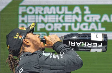  ?? FOTO: GABRIEL BOUYS/DPA ?? Und auf der Flasche steht „Ferrari“: Mercedes-Pilot und Portimão-Sieger Lewis Hamilton dürfte das kaum gestört haben.