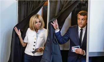  ?? AFP ?? Präsident Emmanuel Macron mit seiner Frau Brigitte bei der Stimmabgab­e.