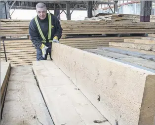  ?? Cp Photo/paul chiasson ?? A worker tidies up the woodpile at a lumber yard Tuesday, April 25, in Montreal. Canada’s softwood lumber industry faces average duties of about 27 per cent after the U.S. Department of Commerce slapped it with an additional 6.87 per cent in...